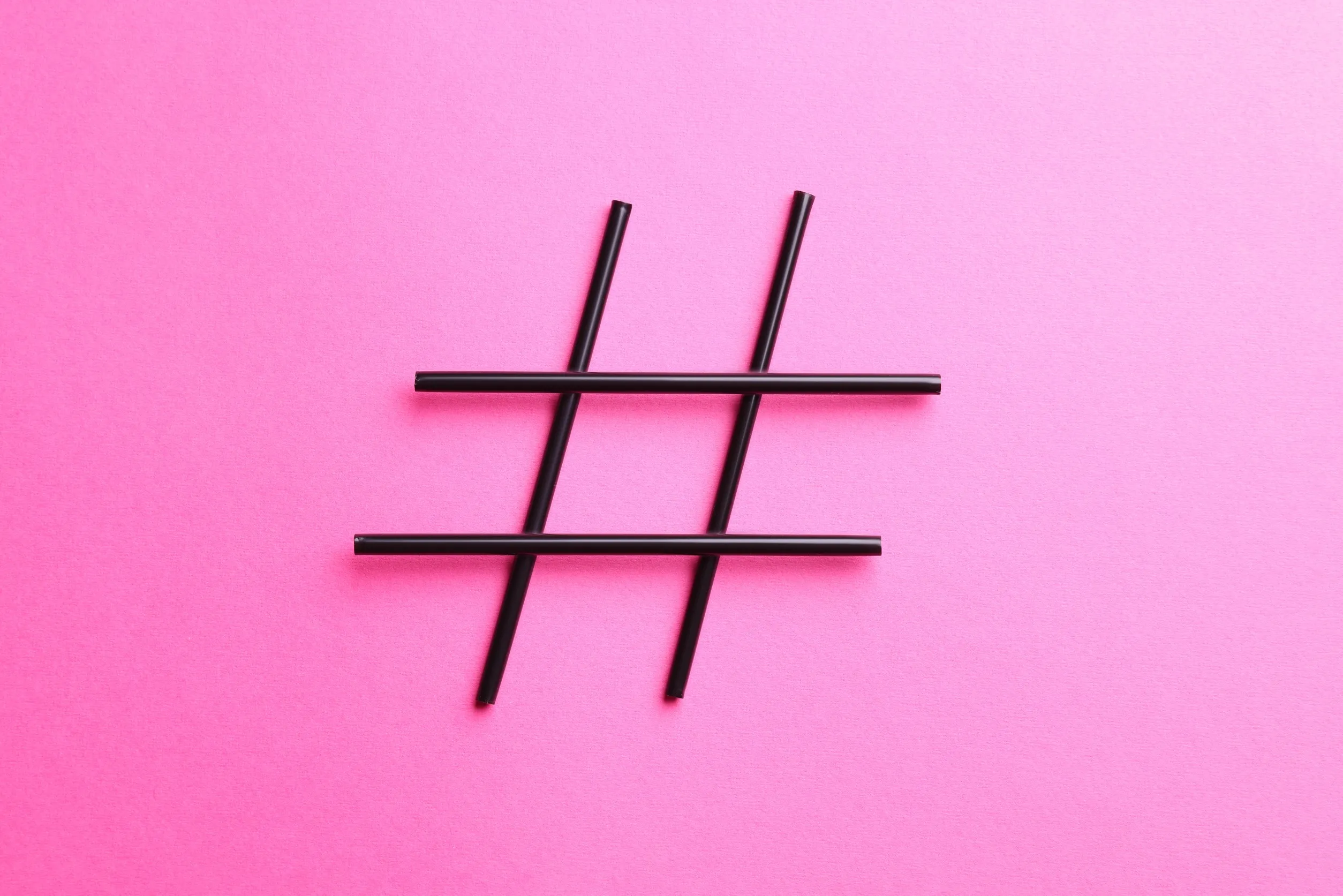 Hashtag symbol made of drinking straws on pink background